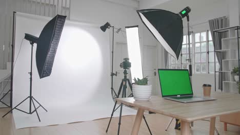 photo studio with professional equipment and green screen laptop computer display