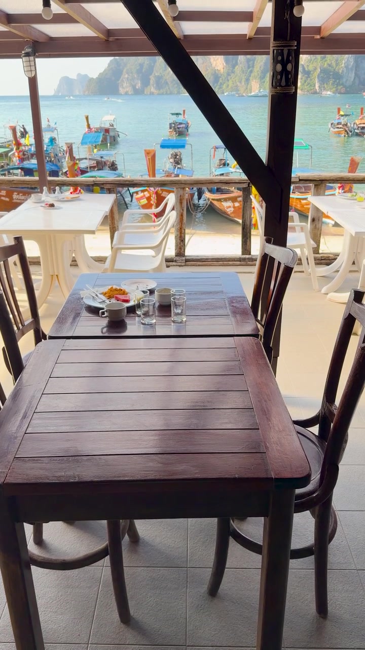 La telecamera si inclina verso l'alto da una colazione all'inglese completa per rivelare una vista tropicale sul porto oceanico