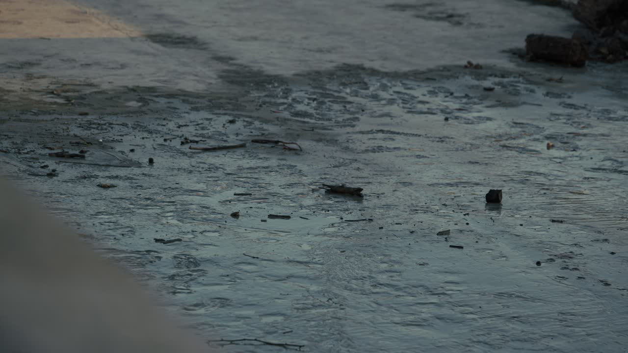 Wet and muddy ground covered in debris after floodwaters receded, Budapest, Hungary