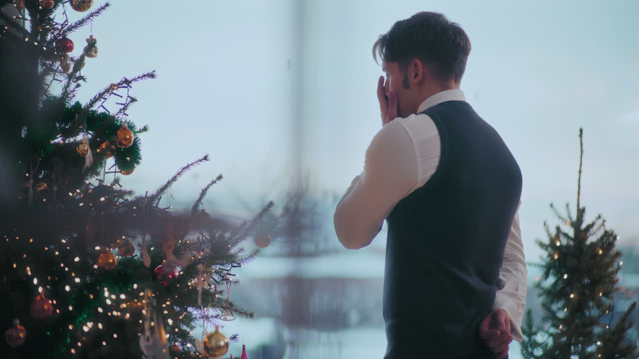 집 에서 장식 된 크리스마스 트리  에 서 있는 우울 한 남자