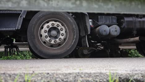 heavy machinery road cleaner moves across asphalt road, view below guardrailing