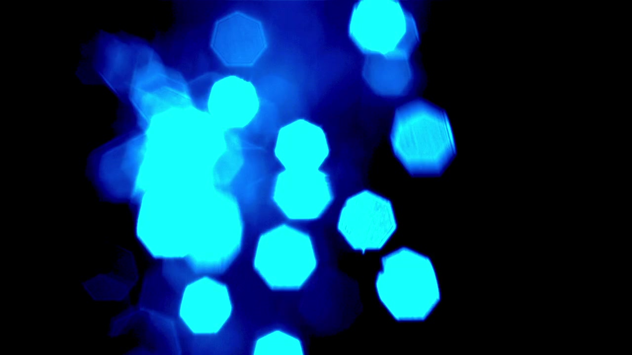 Bevægelige blå sekskantede bokeh-lys på en mørk baggrund