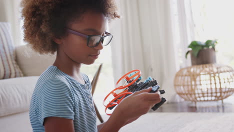 Pre-teen-African-American-girl-sitting-on-the-floor-building-construction-kit-toy,-close-up,-head-and-shoulders