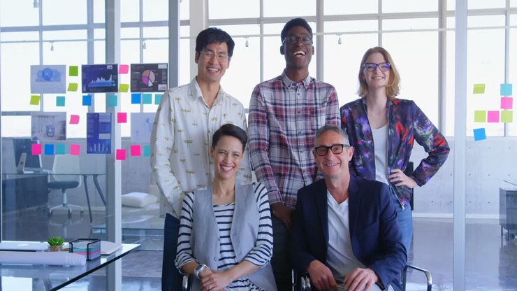 Multi-ethnic business colleagues posing together in modern office 4k