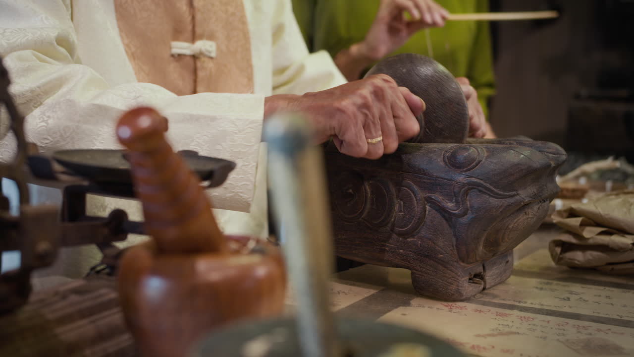 Hands of Man Using Antique Herbs Roller for Grinding Ingredients