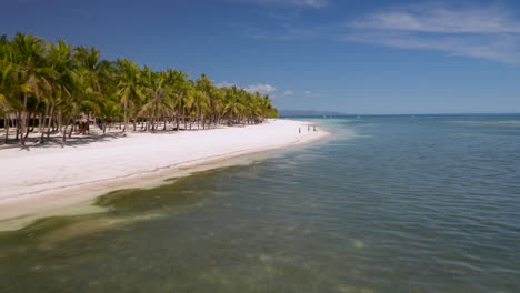antena volando bajo sobre agua mostrando playa privada de bohol beach club en la isla de panglao