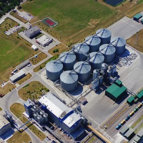 silver silos on agro plant. manufacturing plant for processing drying cleaning and storage of agricultural products. flour, cereals and grain. granary elevator. aerial view video.