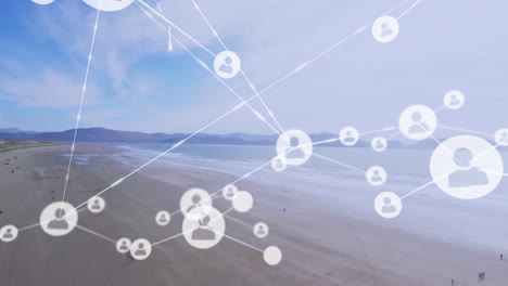 animación de una red de iconos de perfil contra una vista aérea de una playa y el mar