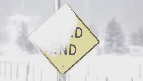 dead end sign covered in snow from blizzard