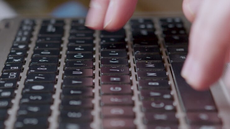 Woman's Finger Typing On Laptop Keyboard