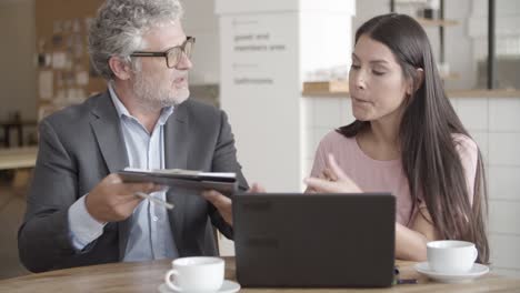 grey-haired senior businessman showing points of document to his client