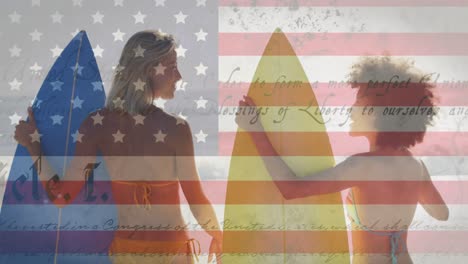 Verfassungstext-über-Amerikanischer-Flagge-Vor-Rückansicht-Zweier-Frauen-Mit-Surfbrettern-Am-Strand