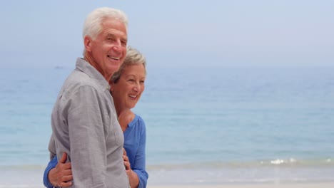 Old-couple-hugging-facing-the-sea