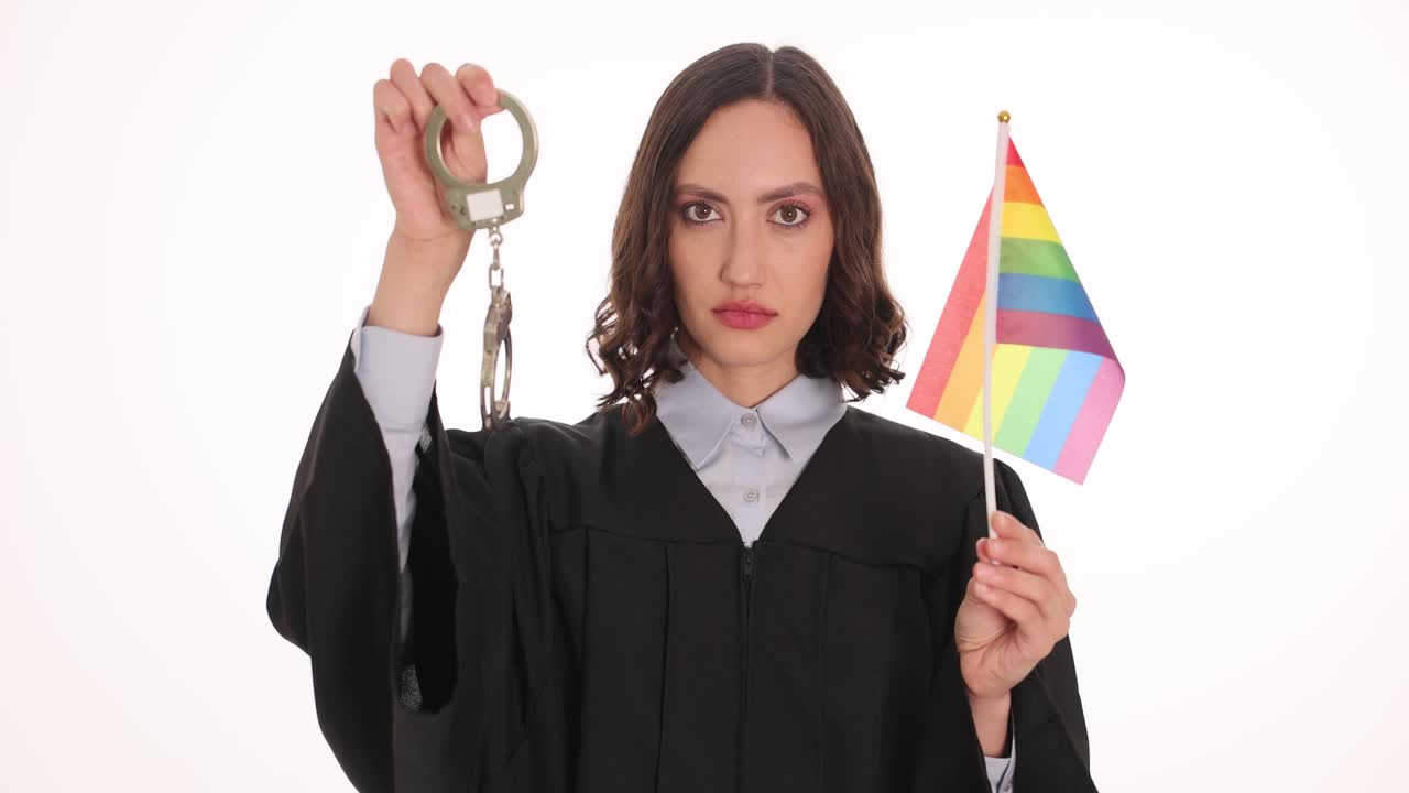 Judge holding LGBTQ flag and handcuffs