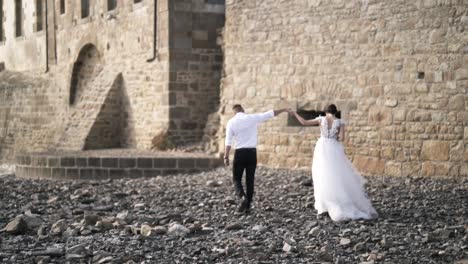 couple walking on the beach near a castle