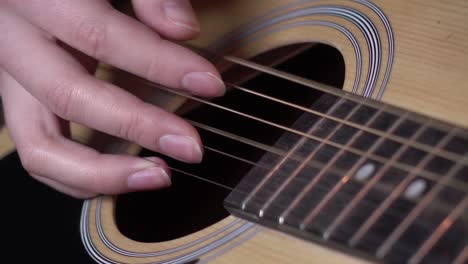 primer plano de manos tocando una guitarra acústica