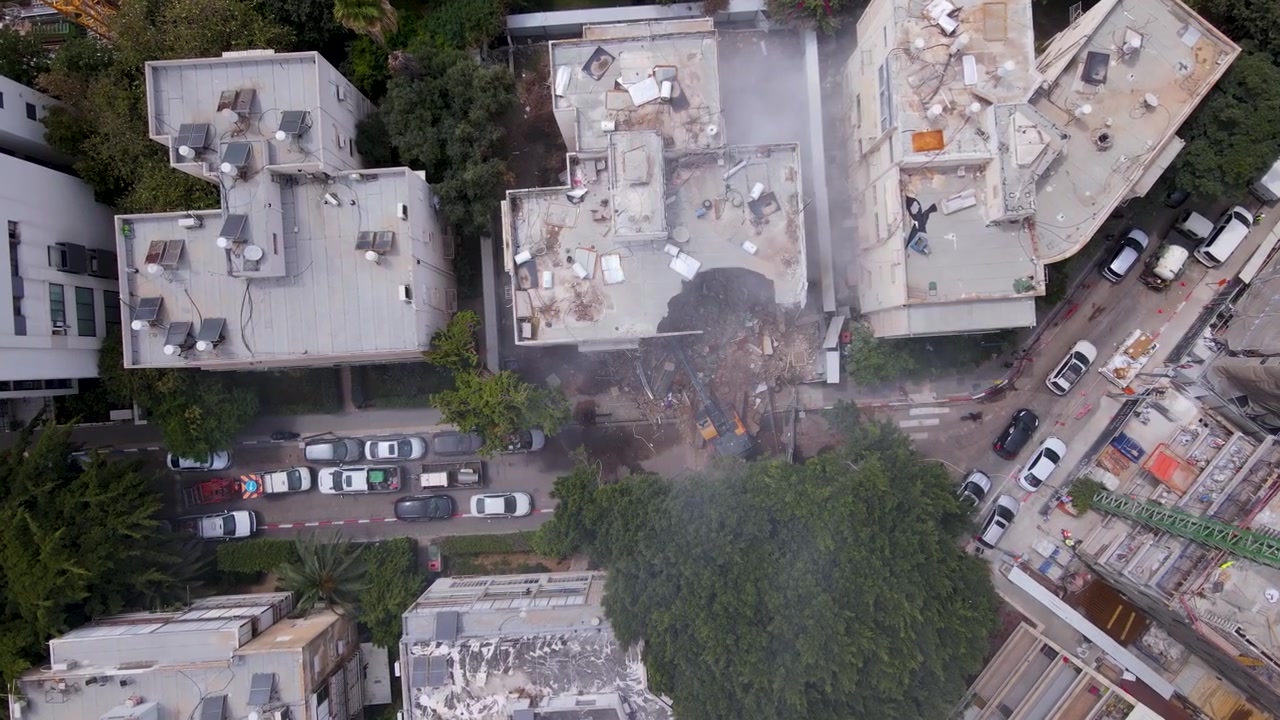 Drone che scende verticalmente sopra il tetto di un edificio bombardato a Tel Aviv.