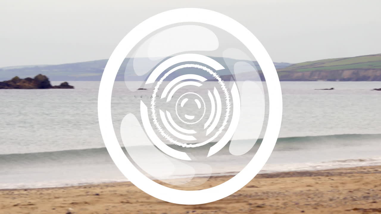 Spinning circular patterns animation over waves crashing on sandy beach