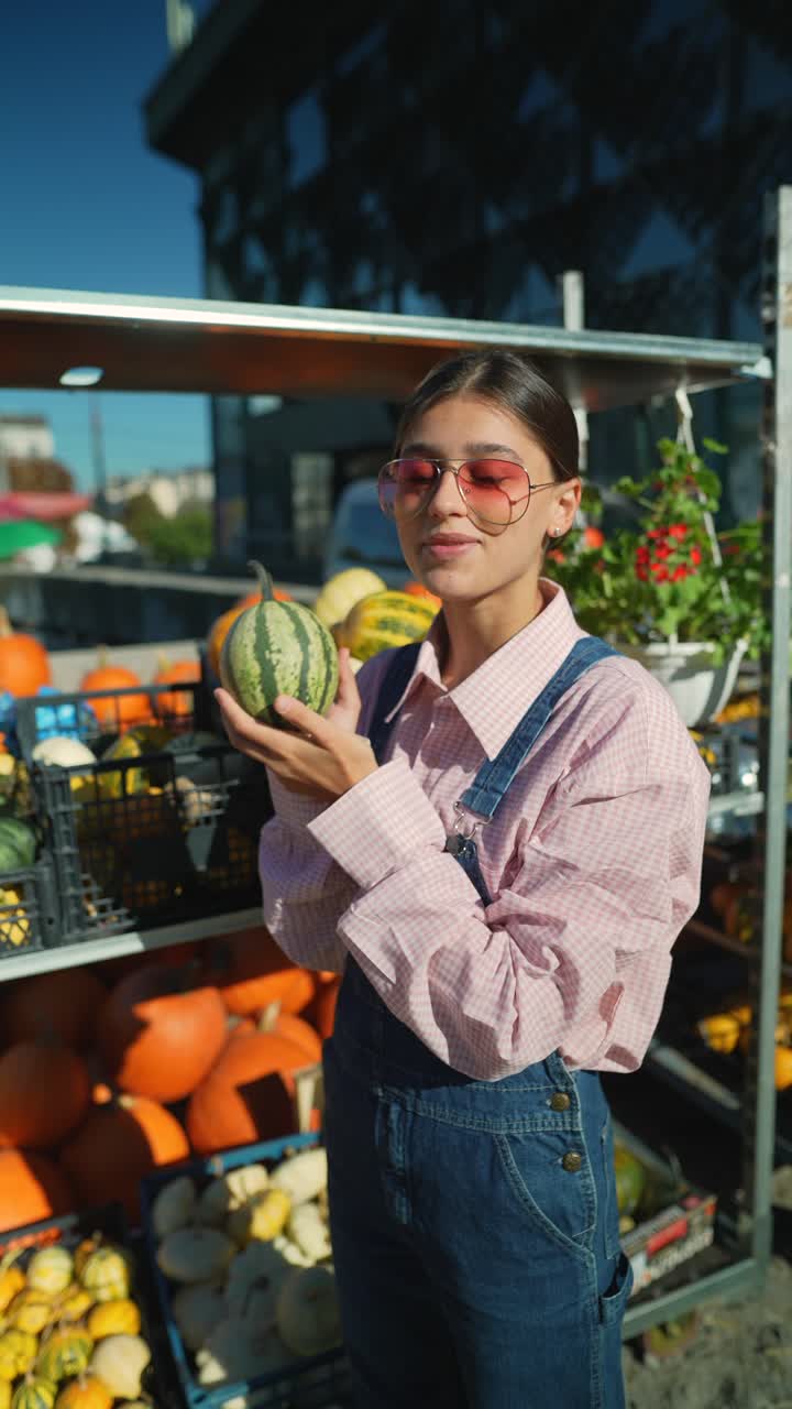 mujer comprando calabazas en un mercado de agricultores