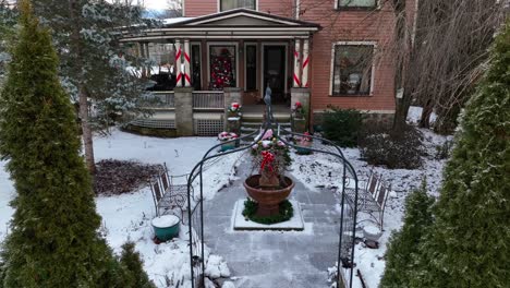 tilt up reveal of snow covered home decorated for christmas in american small town