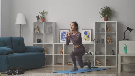 Mujer-Joven-Agachada-Y-Saltando-Entrenando-En-Casa-Haciendo-Ejercicio-En-Autoaislamiento-Y-Encierro-Perdiendo-Peso-Y-Estilo-De-Vida-Saludable