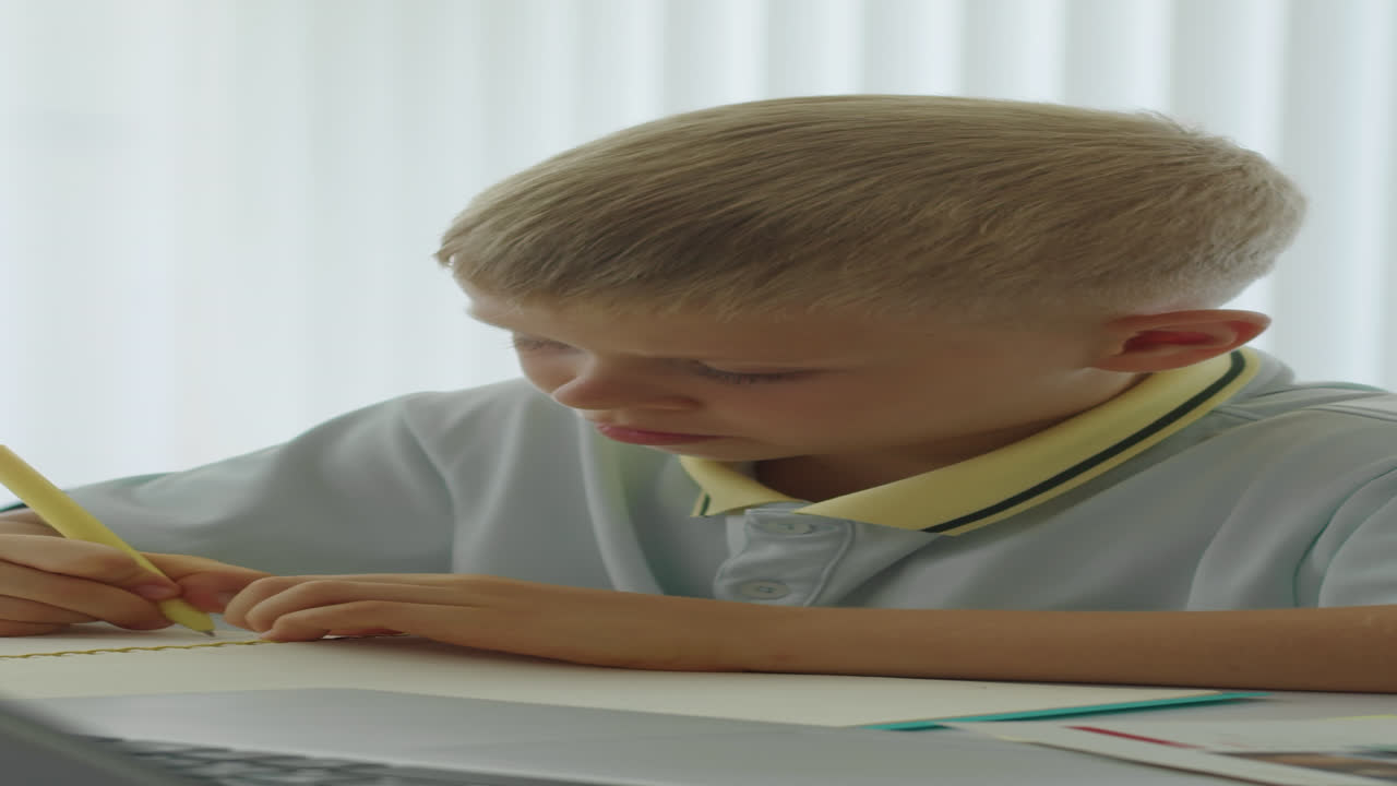 Schoolboy Writing Test at Desk in Classroom