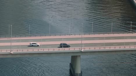 aerial view of car traffic moving on bridge above river