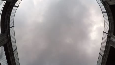 timelapse of clouds slowly covering the sky from the bottom of a circular parking lot