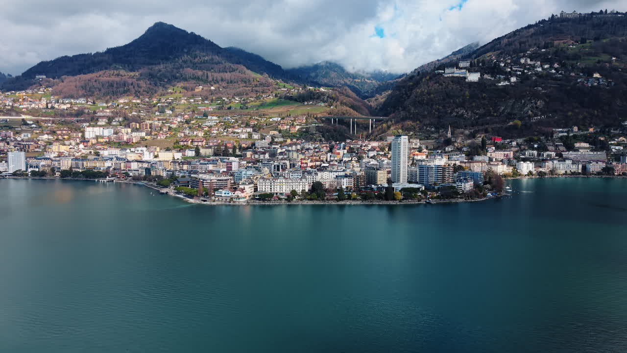 Ripresa aerea con drone che si allontana del paesaggio urbano di Montreux con il Lago di Ginevra di giorno nel Canton Vaud, Svizzera.