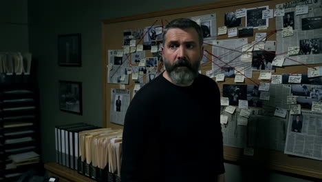 man investigating a crime evidence board