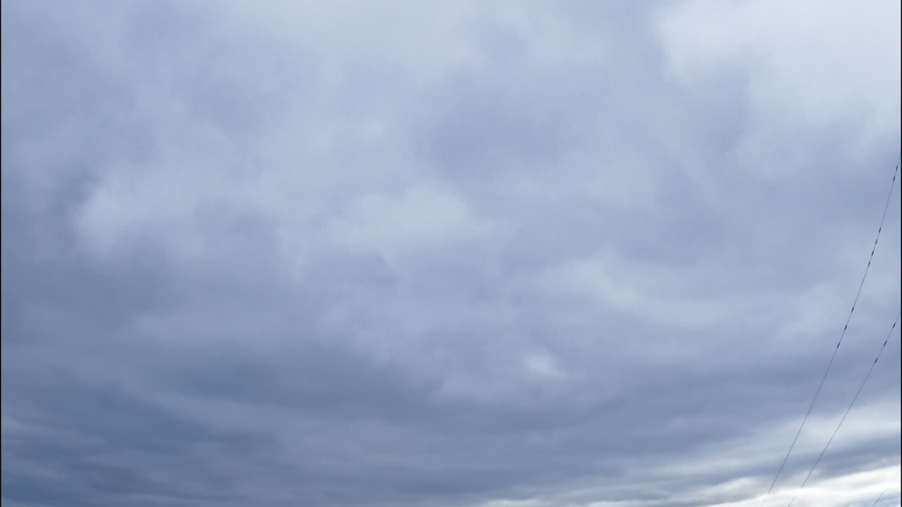Grey thick cloudscape totally covering the sky. Dramatic cloudscape formation. Low angle view.