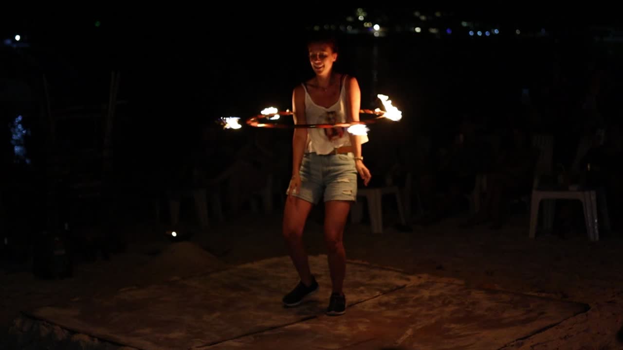 Sexy girl fire twirling show entertainment on the beach