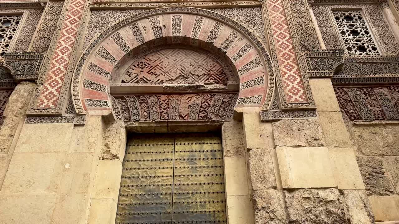North gate of Córdoba’s Mezquita-Catedral, featuring detailed stonework, horseshoe arch, and Islamic geometric patterns from Andalusian heritage.