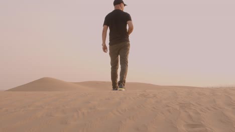 Young-man-walking-in-the-desert-in-hostile-environment