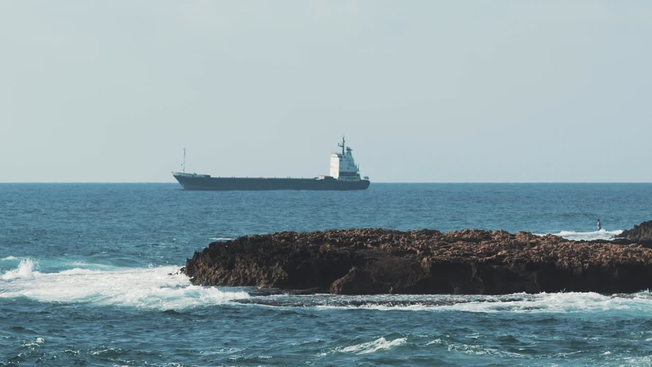 Sea and coastal waves scene near the city of Beirut with a small island in the middle.