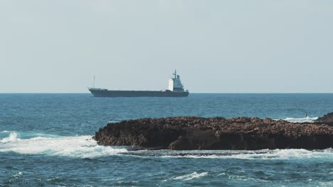 sea and coastal waves scene near the city of beirut with a small island in the middle.