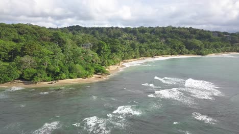 Rocket-shot-of-tropical-jungle-at-beach-with-waves-in-central-america