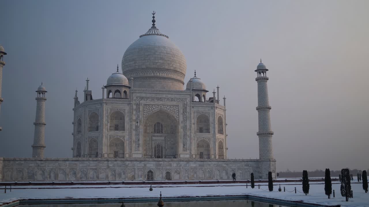 Wide-angle shot of the Taj Mahal at dawn, capturing its majestic architecture and serene atmosphere