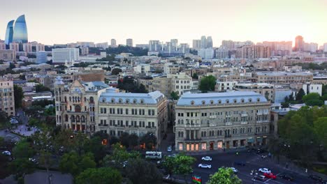 Walled-town-İçərişəhər-aerial-view-in-Baku-centre-against-urban-skyline-at-sunset,-Azerbaijan