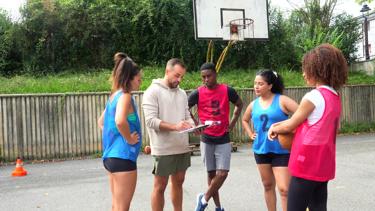 Équipe de basket-ball avec entraîneur sur un terrain extérieur