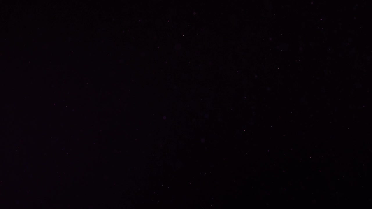 Floating Dust Particles on a Black Background with Bokeh Effect