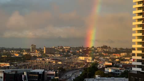 Der-Himmel-Klart-Nach-Einem-Heftigen-Regen-Am-Nachmittag-Auf,-Ein-Wunderschöner-Regenbogen-Mit-Goldener-Sonne,-Der-über-Den-Bahnhof-Mayne-In-Den-Bowen-Hills-Und-In-Der-Innenstadt-Von-Windsor-In-Brisbane,-Queensland,-Scheint