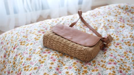 brown straw shoulder bag on floral bedding