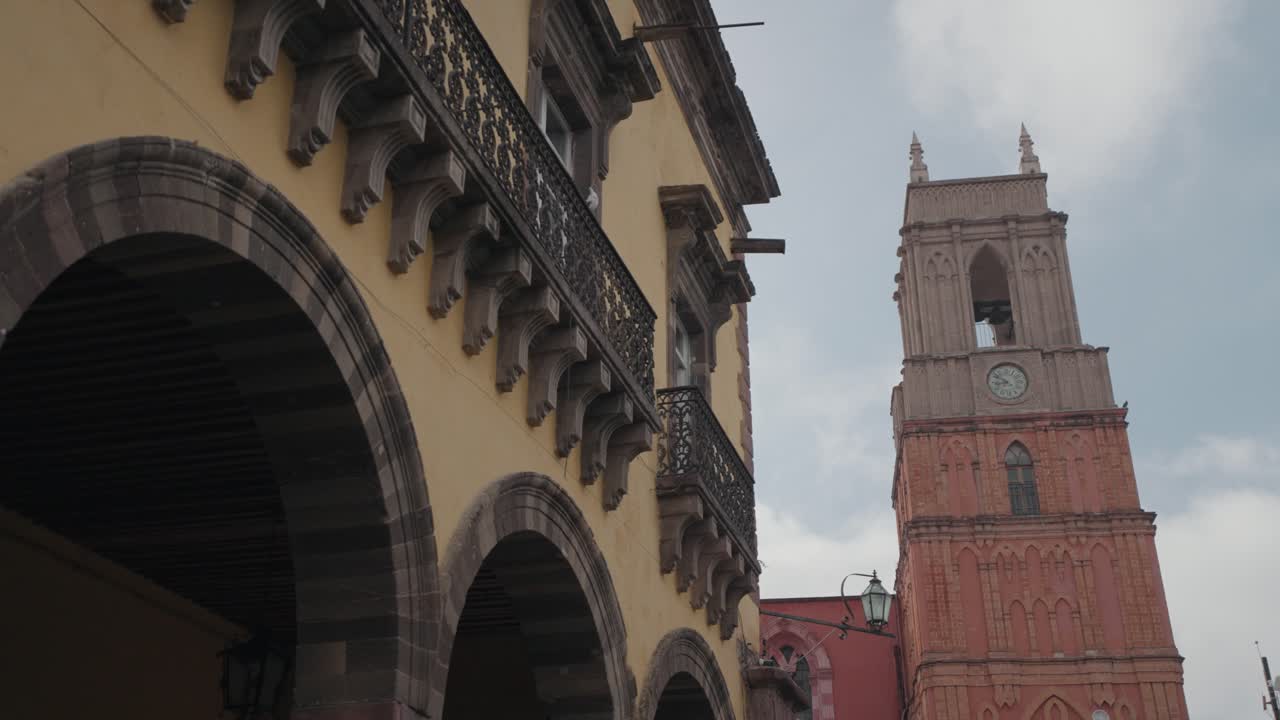 Architecture featuring an arched building and a clock tower