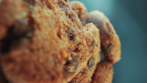 a vertical macro close up cinematic shot of a plate full of crispy chocolate chip cookies, on a rotating stand, studio lighting, slow motion, smooth movement, 4k video