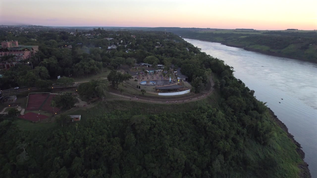 Vista aerea 4K con drone della Triplice Frontiera dove si incontrano Argentina, Brasile e Paraguay. I fiumi Iguazu e Paraná convergono, circondati da lussureggianti paesaggi subtropicali e aree urbane.