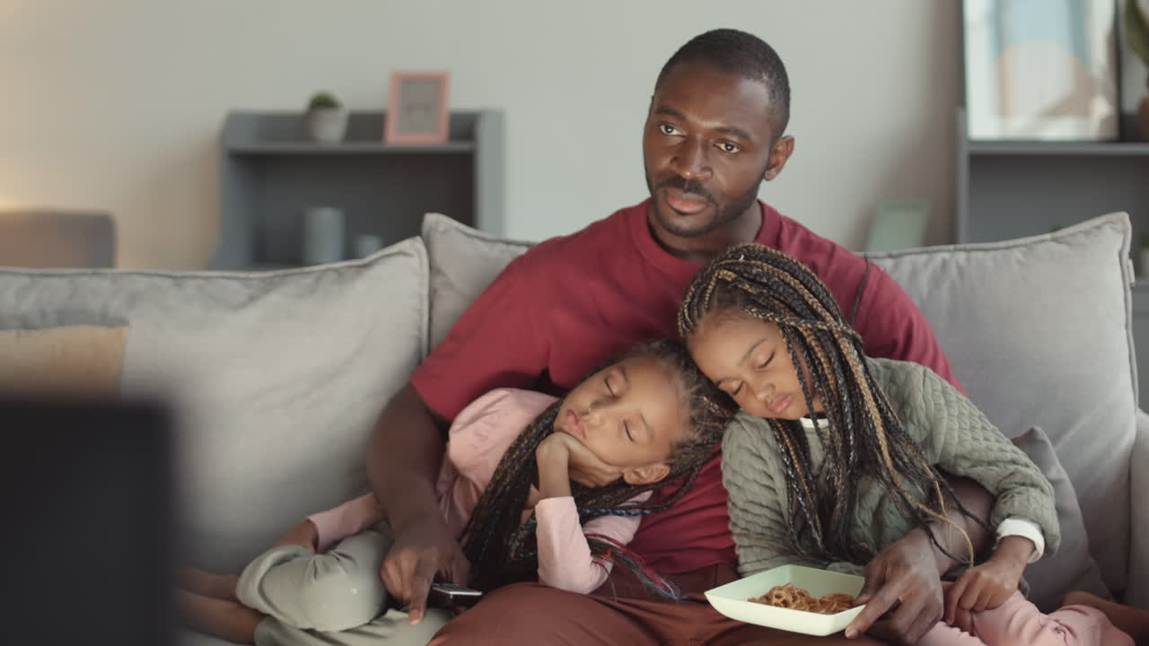 Sorelle che dormono tra le braccia del padre