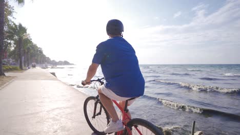 Young-man-riding-a-bike-on-the-beach.