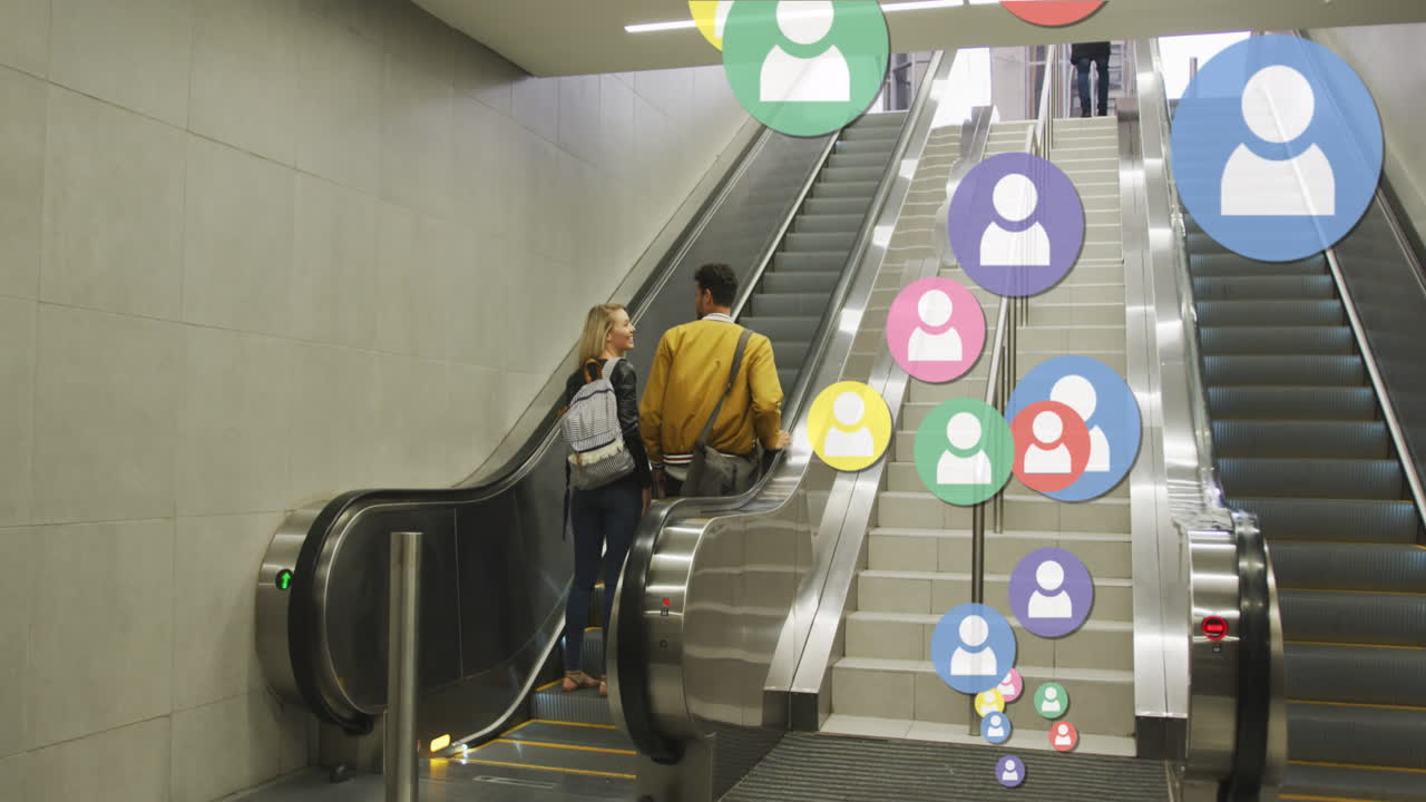 animación de iconos de las redes sociales flotando sobre una feliz pareja caucásica tomados de la mano en las escaleras mecánicas