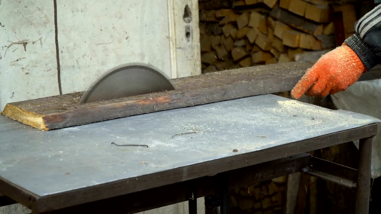 sierra circular. el mago corta una tabla de madera en una sierra circular, primer plano.